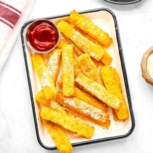 Polenta fries on a plate with ketchup.