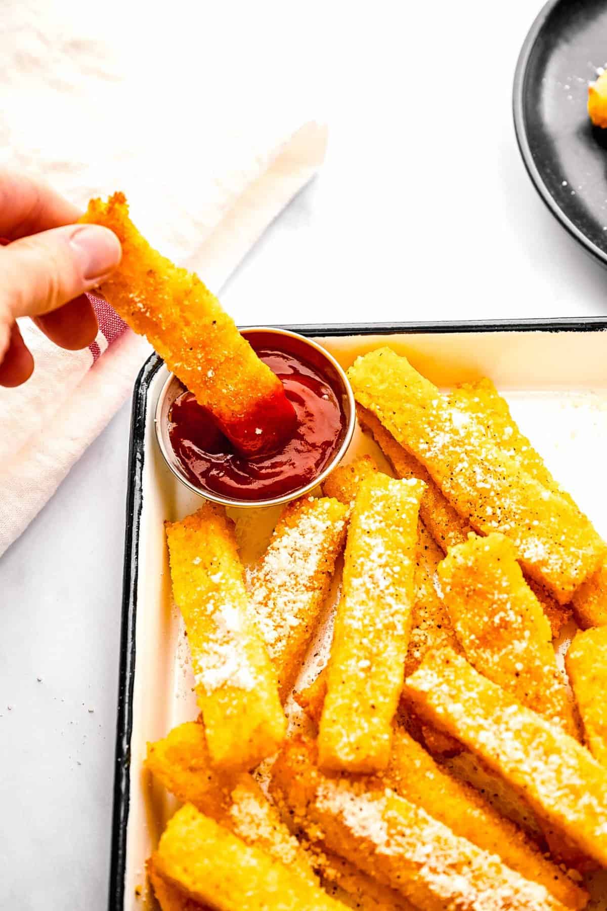 Dipping a polenta fry in ketchup.