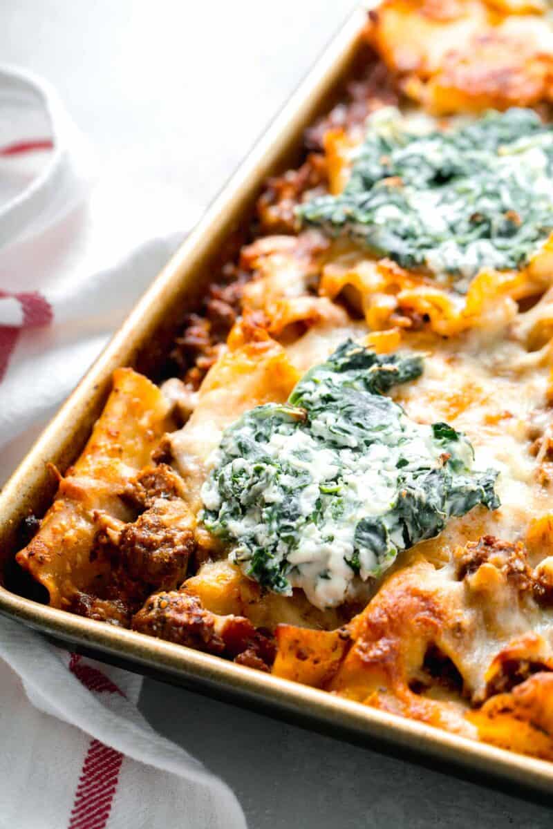 baked sheet pan lasagna with dollop of spinach and ricotta mixture on top
