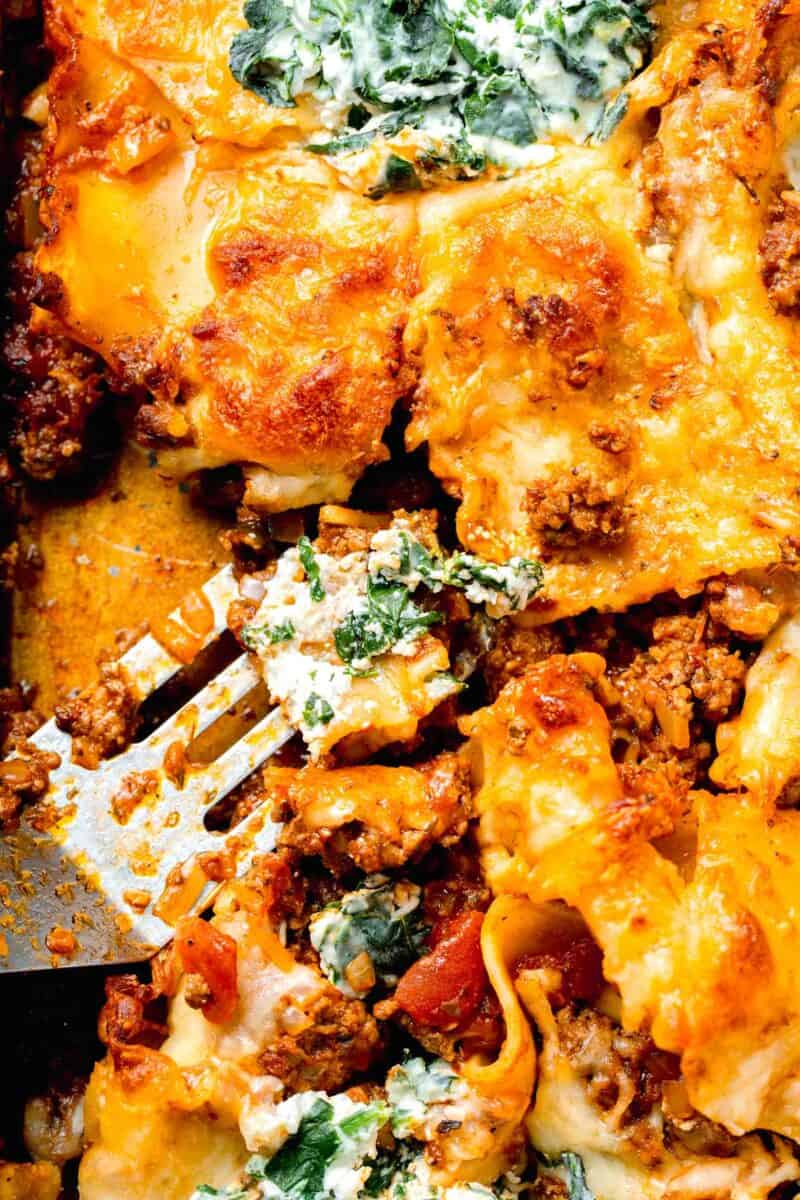 sheet pan lasagna with a piece scooped out from a metal spatula