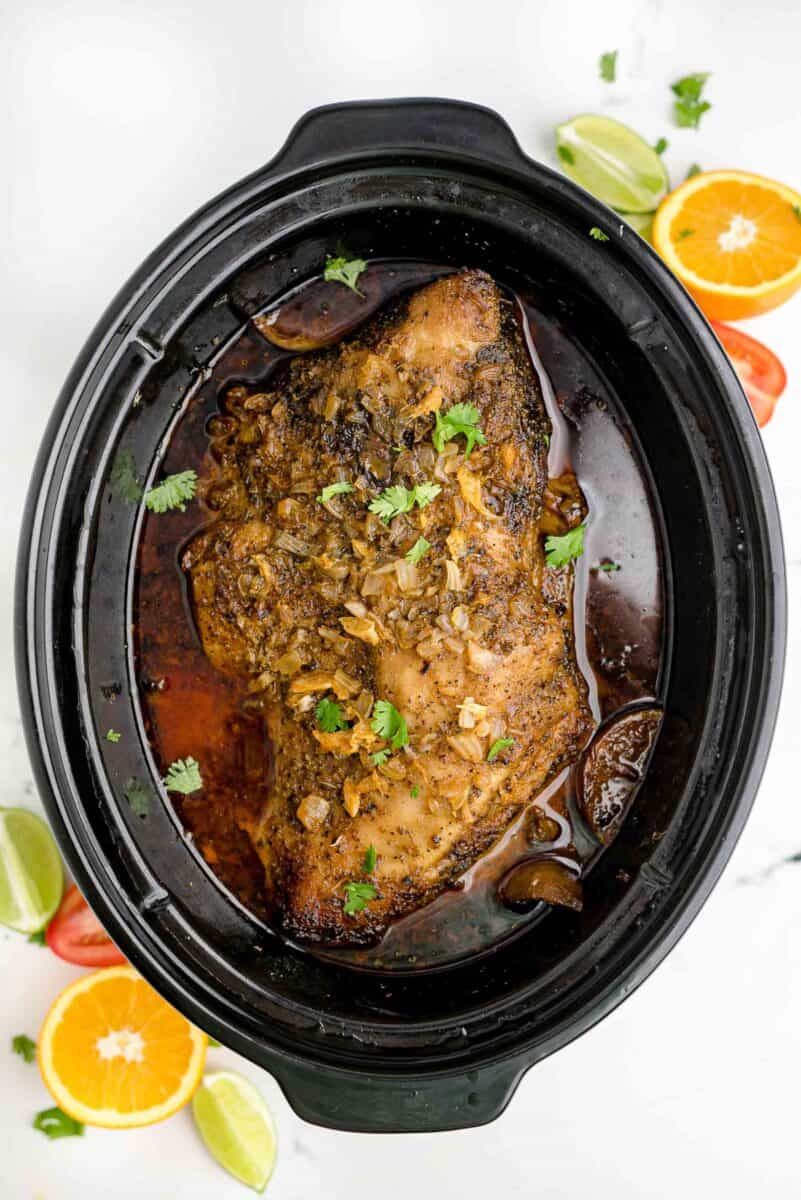cooked pork is presented in a crockpot.