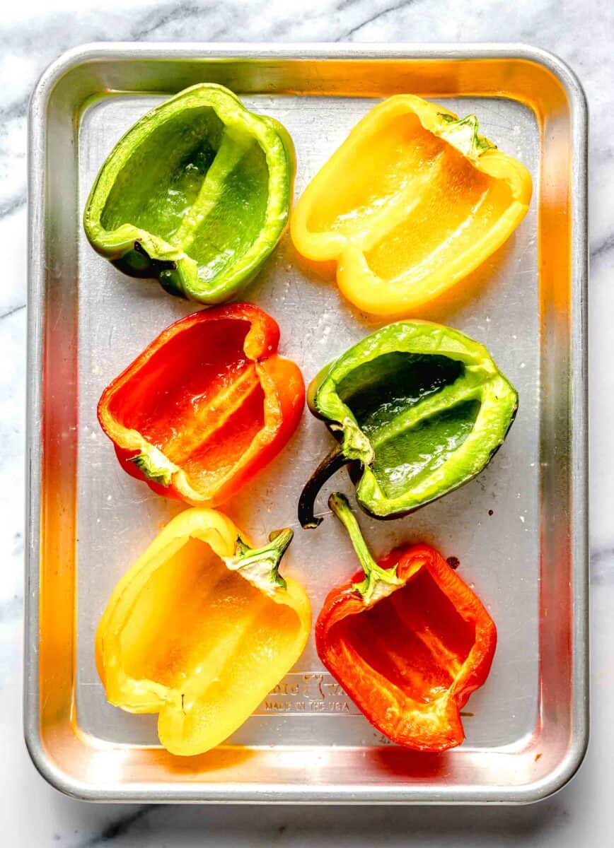 empty bell pepper cavities on a metal baking sheet