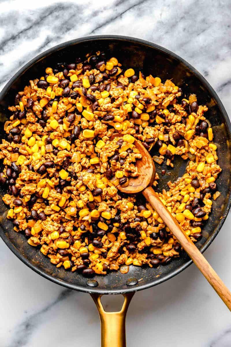 filling for stuffed peppers in a nonstick skillet with a wooden spoon