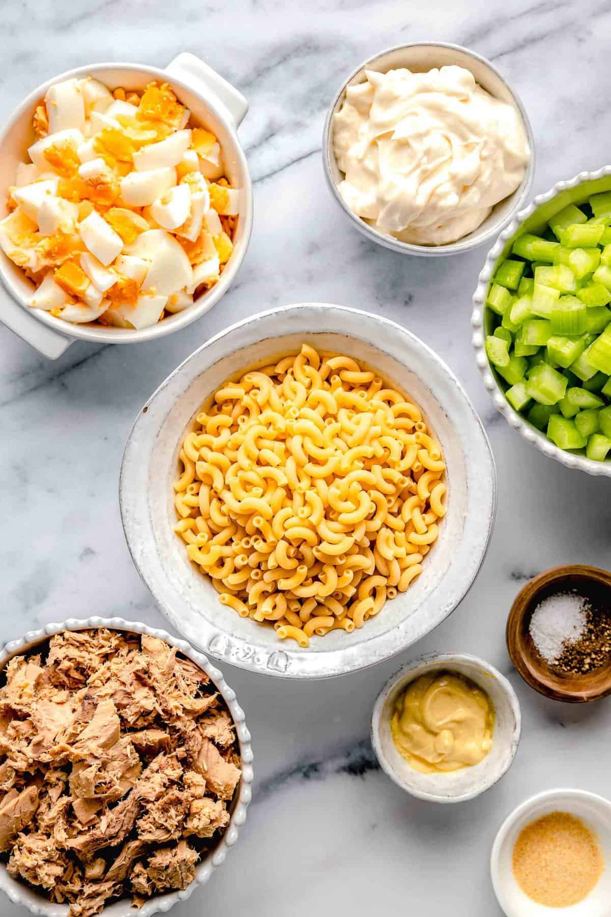 Ingredients for tuna pasta salad separated into bowls.