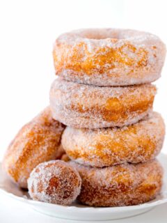 a stack of 4 biscuit donuts with a donut hole in front