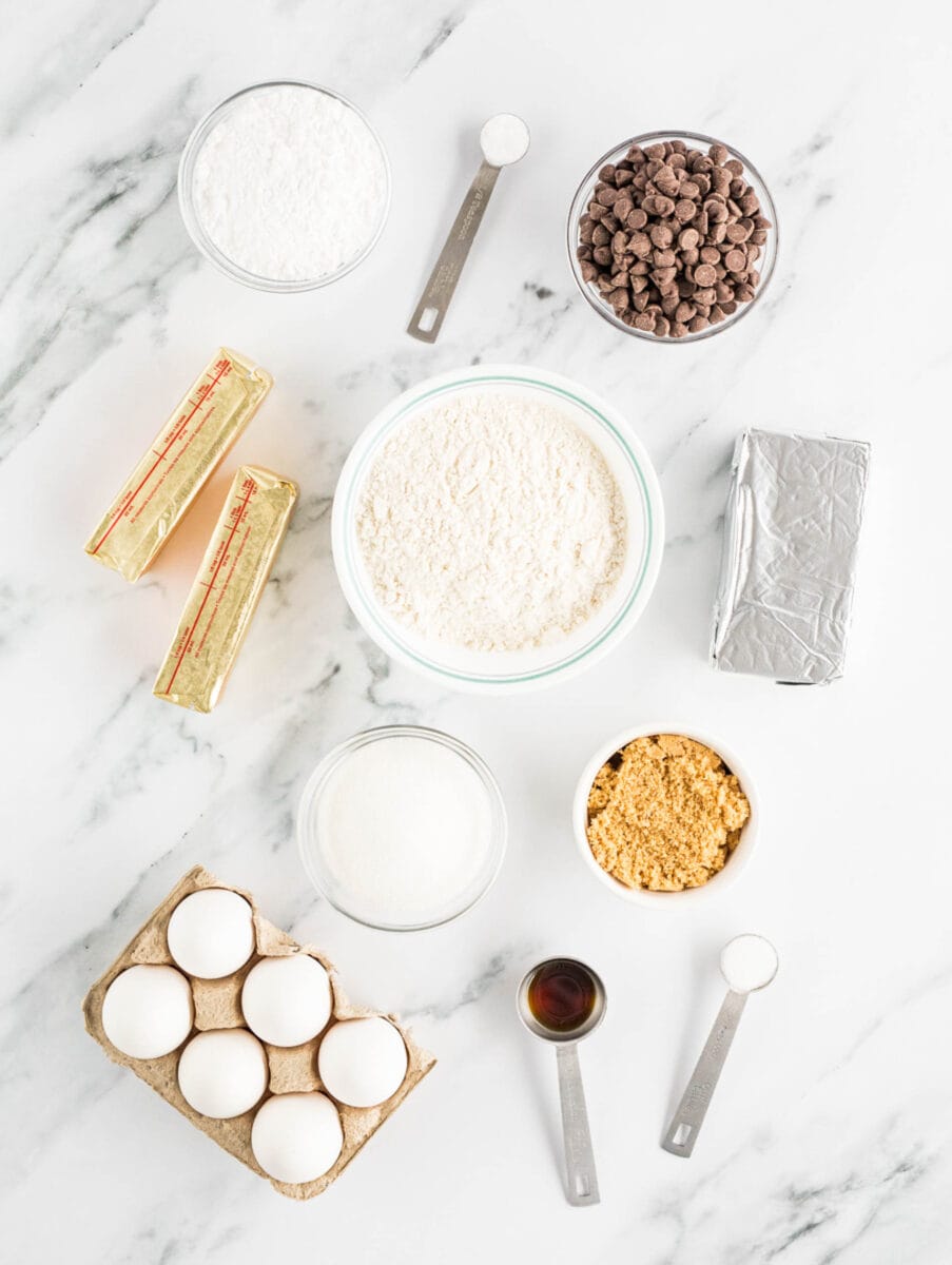 the ingredients for cheesecake stuffed cookies are placed on a white countertop.