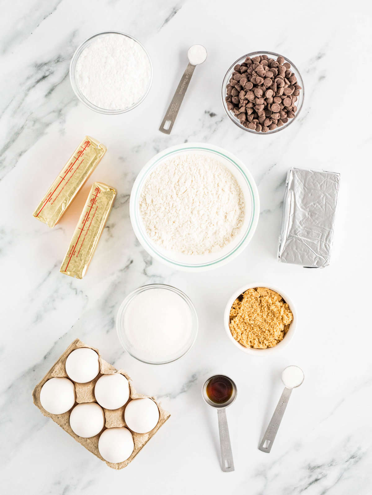 the ingredients for cheesecake stuffed cookies are placed on a white countertop.