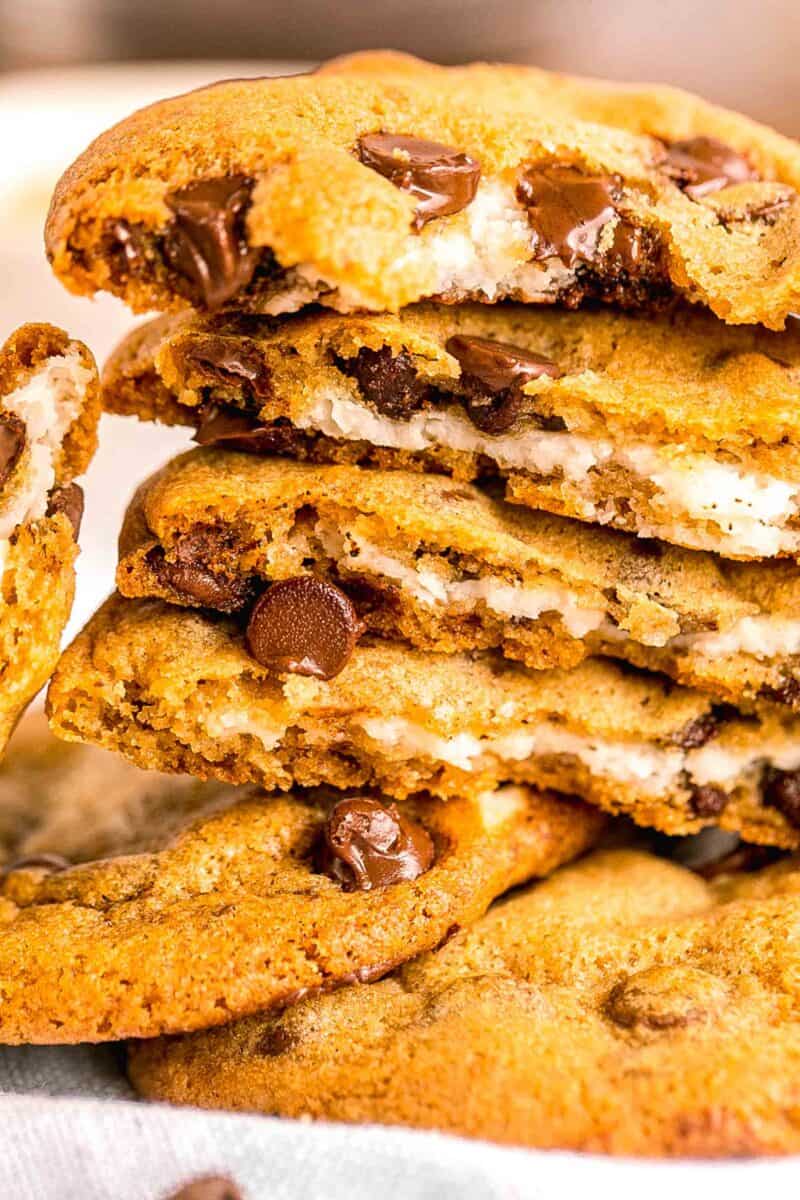 a stack of cheesecake stuffed chocolate chip cookies are presented close up.