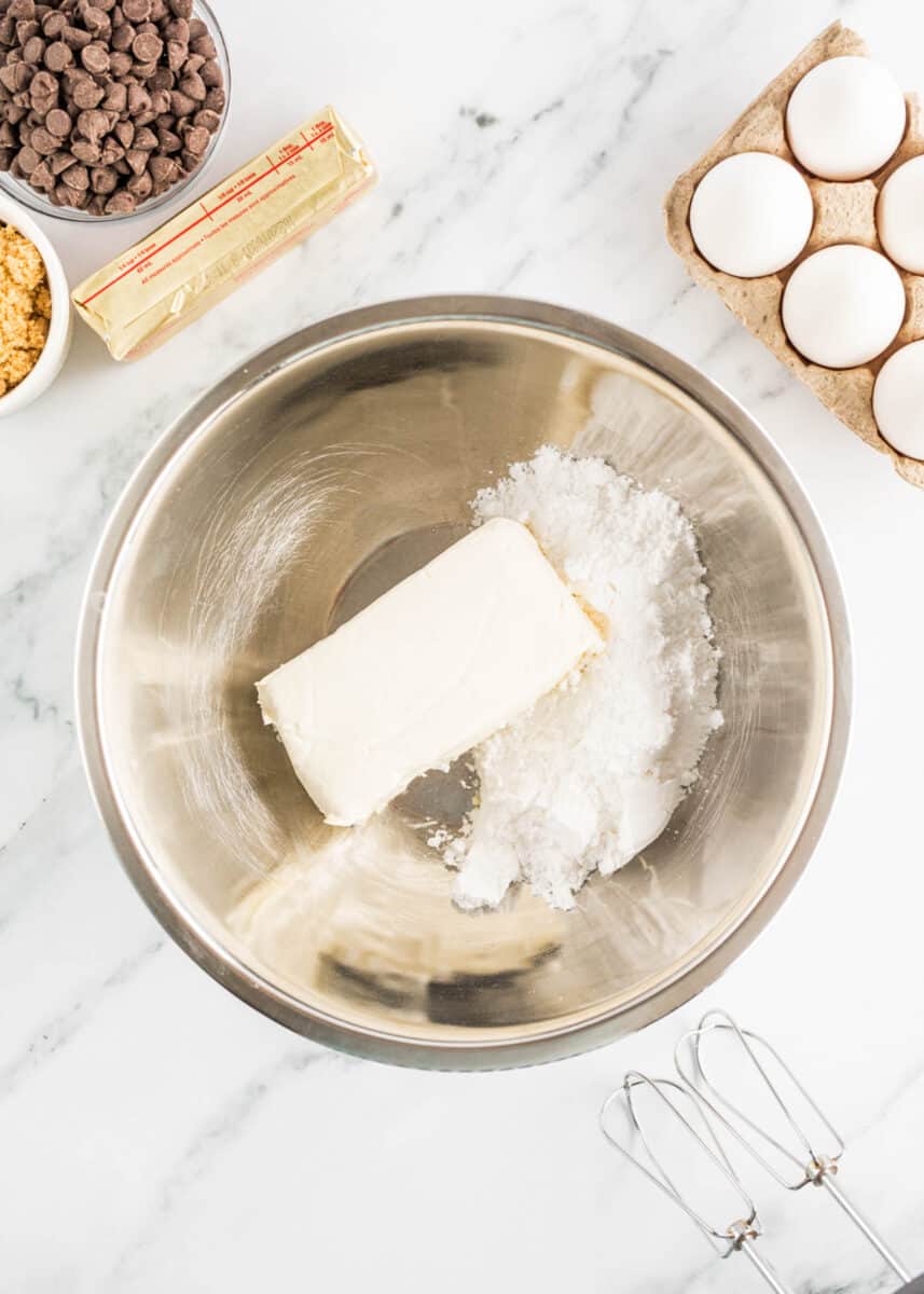 cream cheese and sugar are both placed in a large bowl.