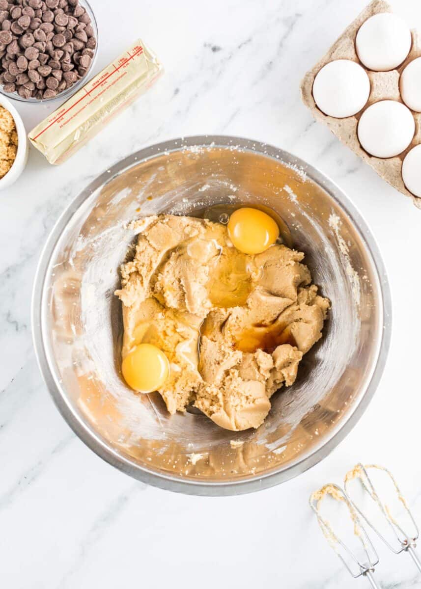 raw eggs are being mixed into the cookie dough.