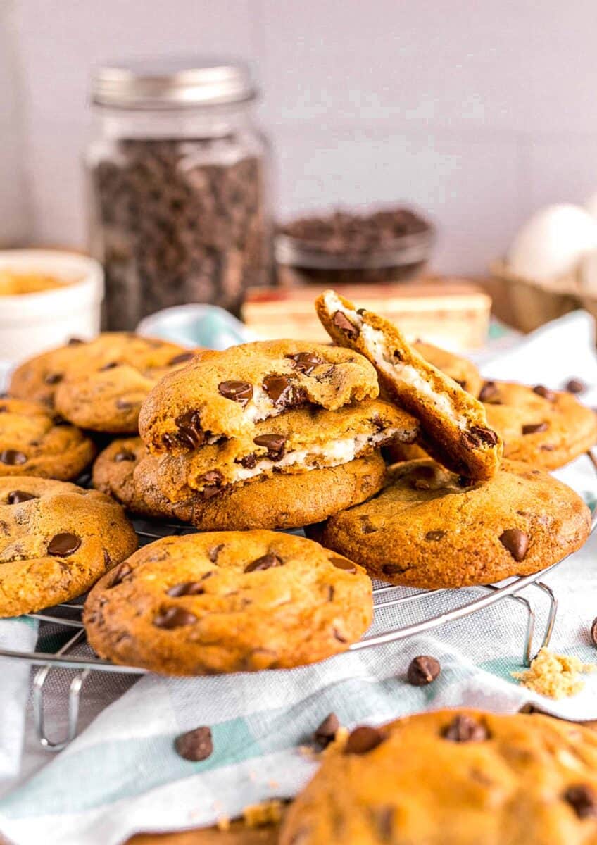 several cheesecake stuffed chocolate chip cookies have been halved to reveal a cheesecake center.