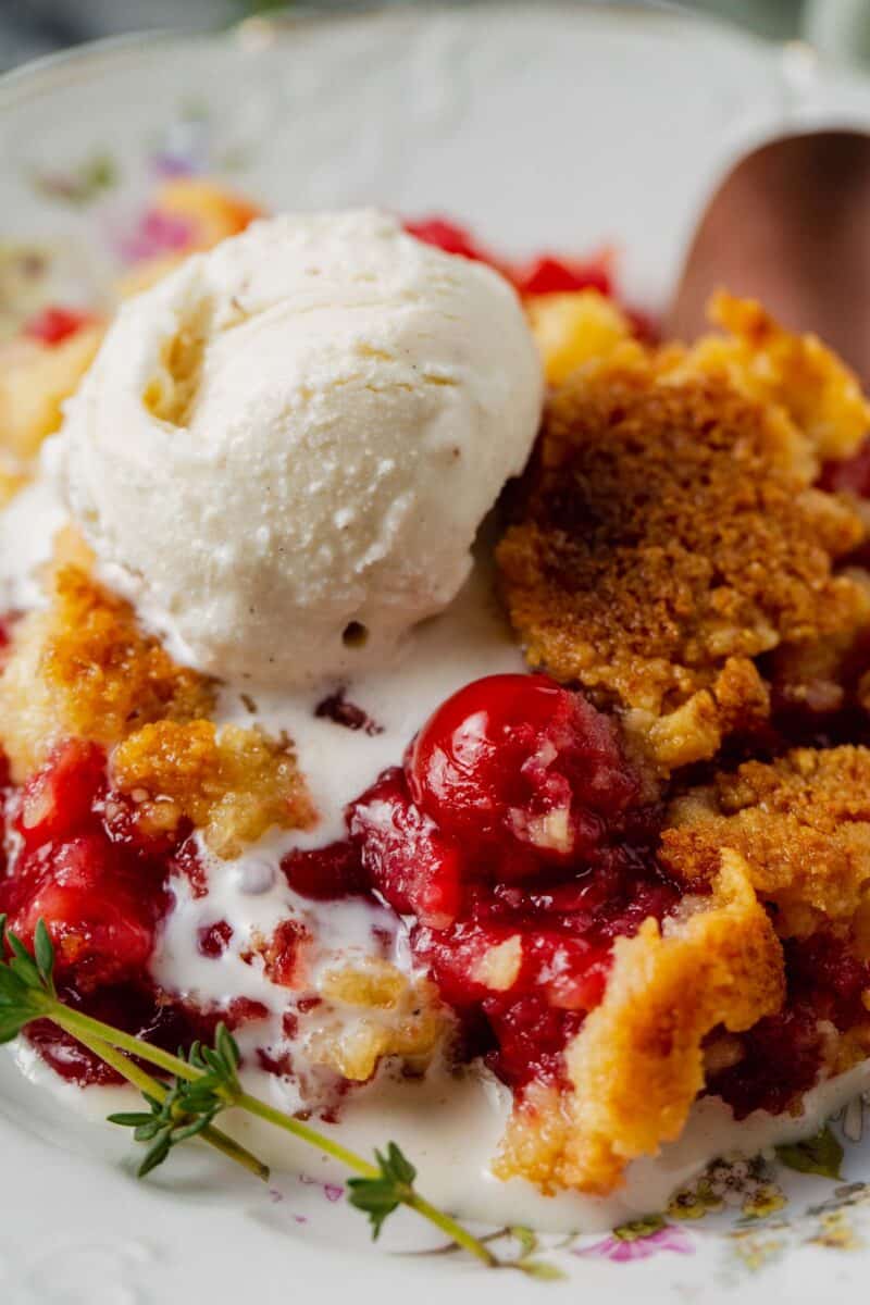 up close image of cherry dump cake and melted vanilla ice cream