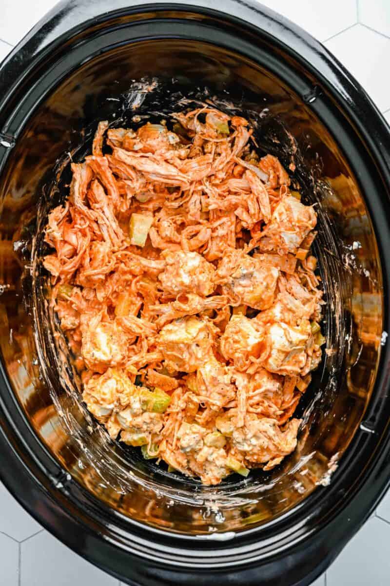 Ingredients for buffalo chicken dip mixed together in a crockpot.