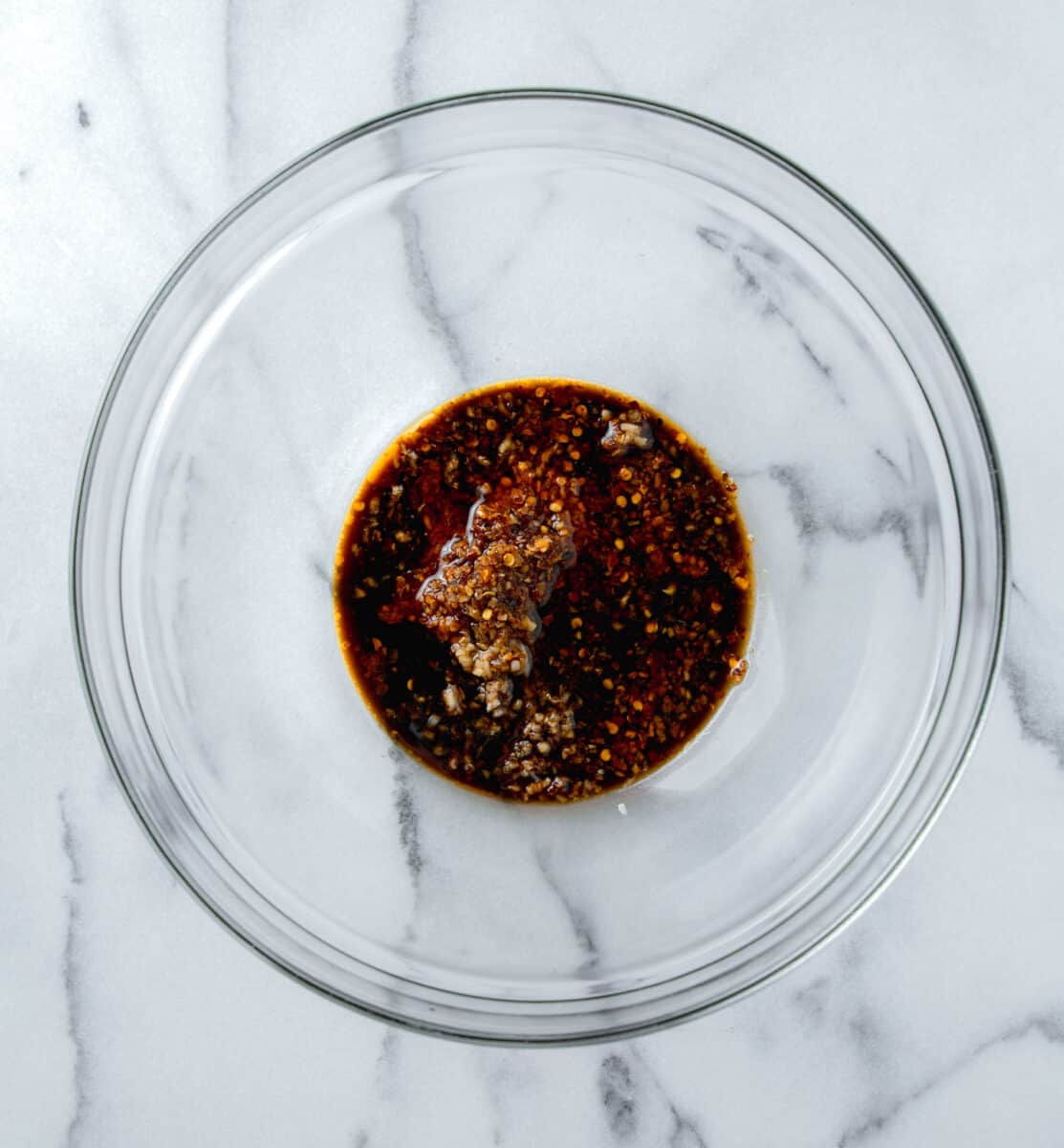 sauce mixture for smashed asian cucumber salad in a clear bowl