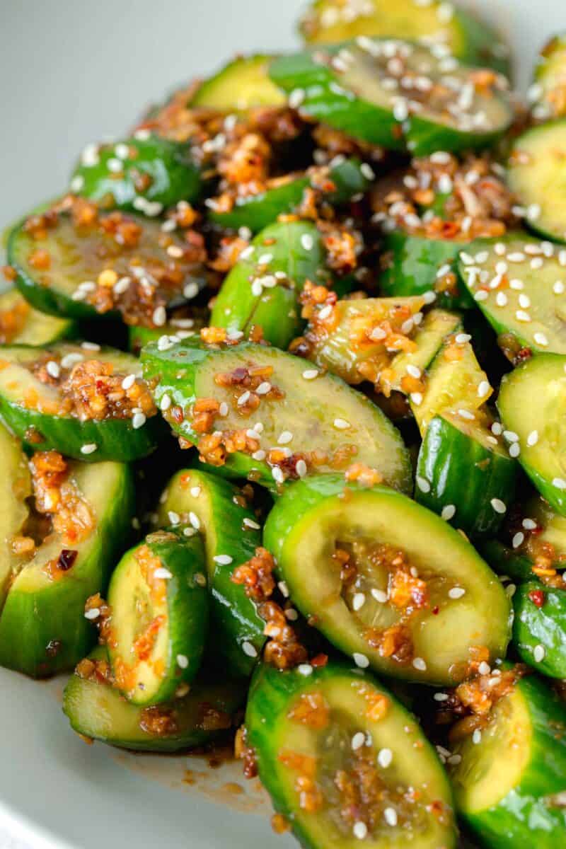 smashed asian cucumber salad with sesame seeds on top and minced garlic flecks