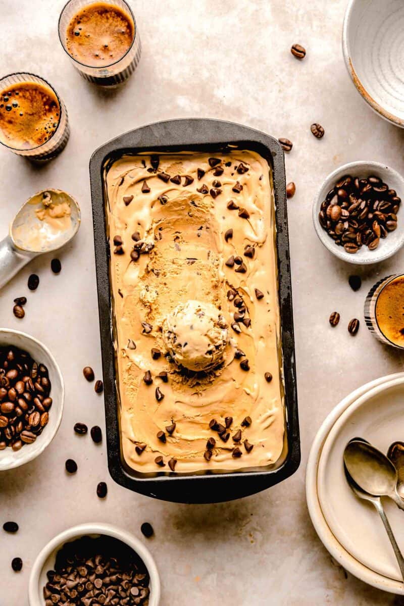espresso chocolate chip ice cream in a loaf pan next to espresso shots and espresso beans
