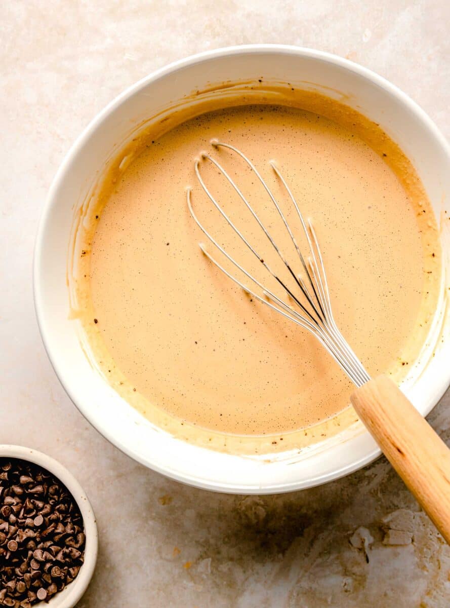 espresso ice cream mixture in a white bowl with a whisk