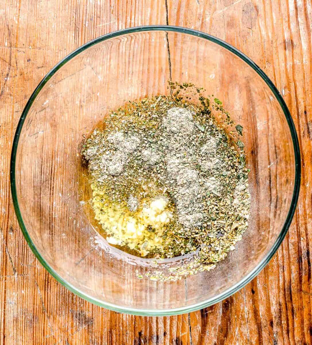 greek seasoning in a clear bowl on a wooden table