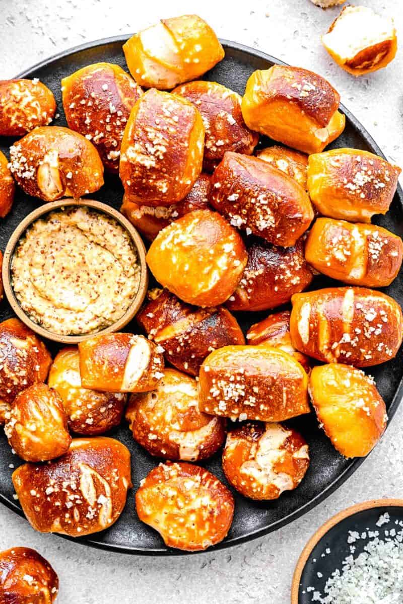 Pretzel bites on a serving plate with whole grain mustard.