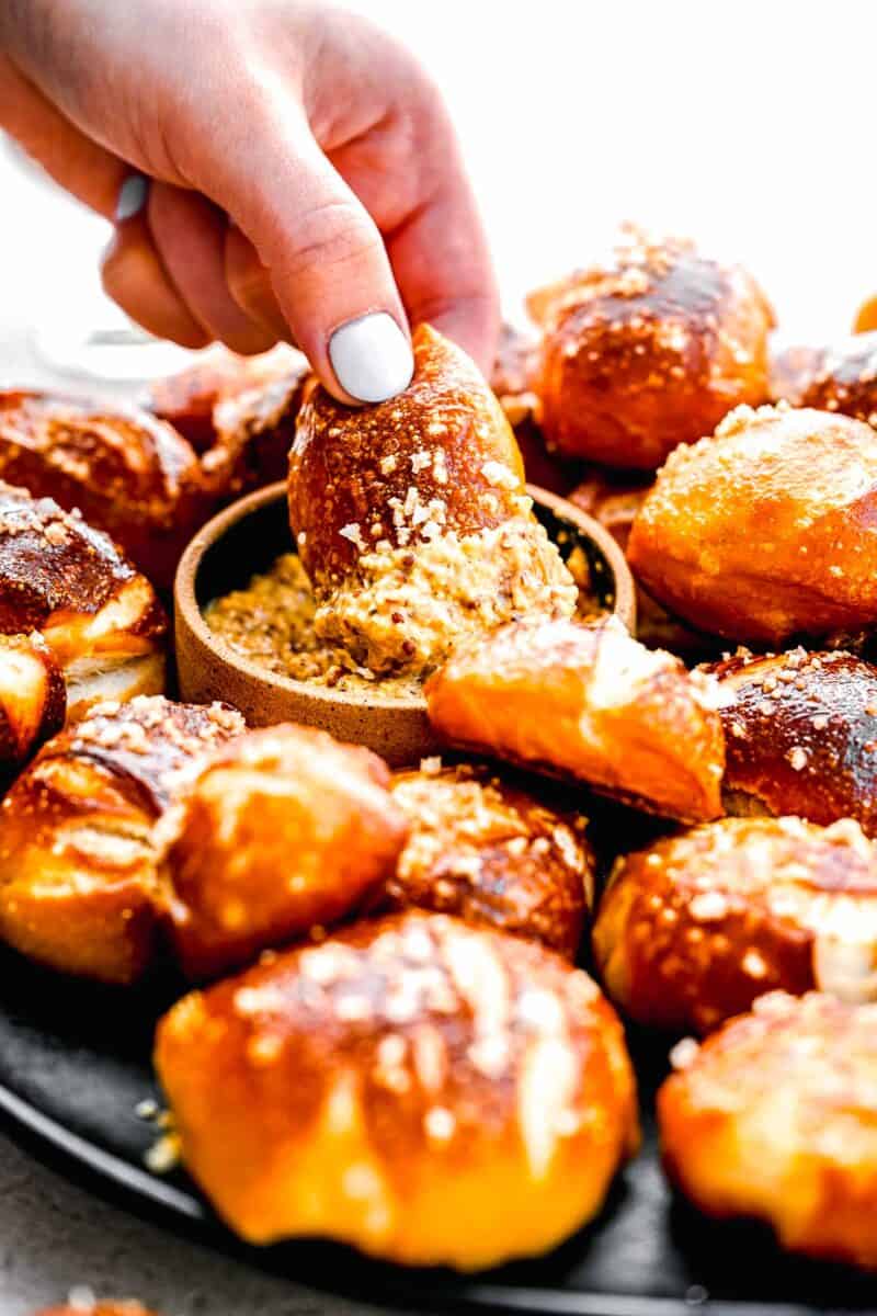 Dipping a pretzel bite in whole grain mustard.