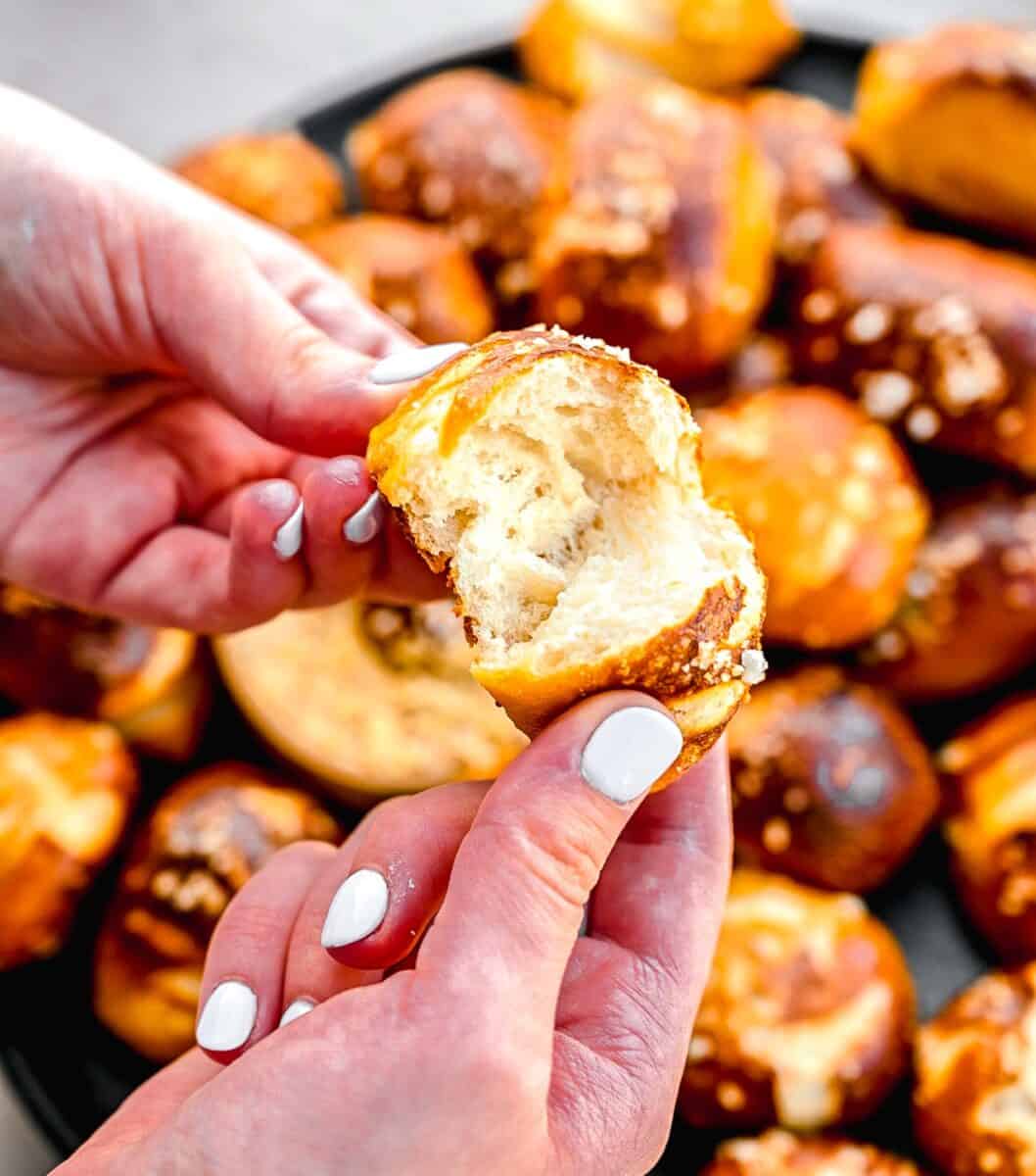 Tearing a pretzel bite in half.