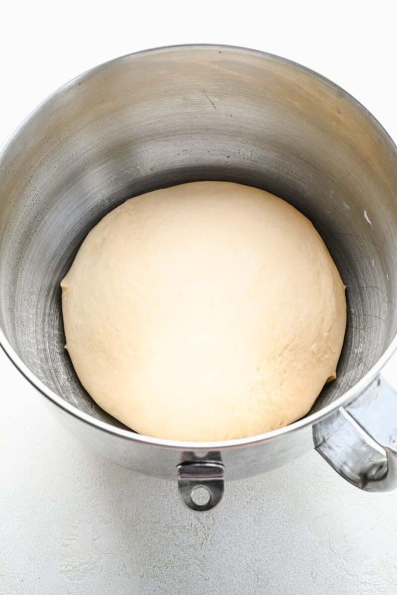 Risen pretzel dough in a mixing bowl.