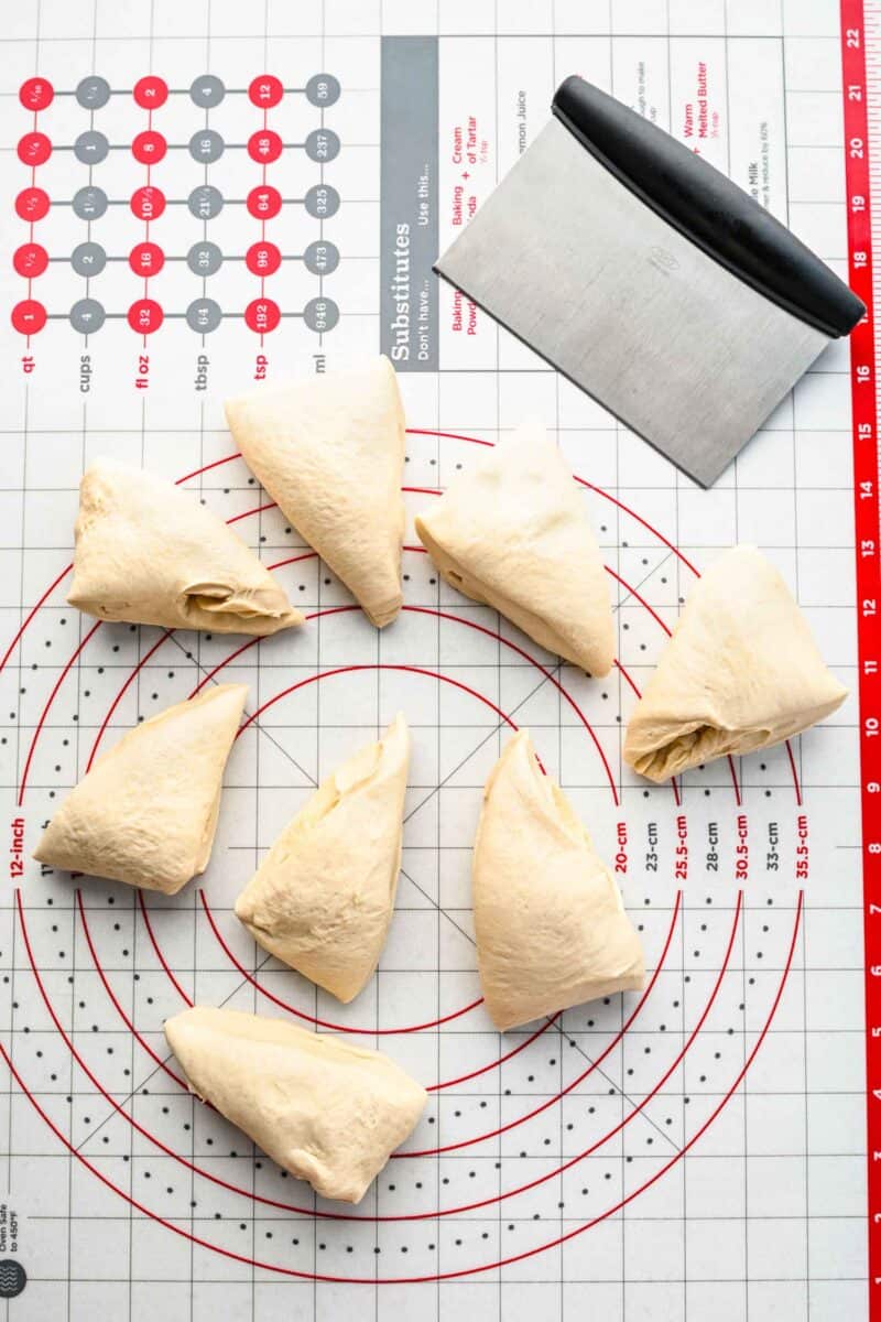 Pretzel dough cut into pieces on a measuring board.