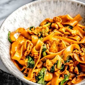 pad see ew in a deep noodle bowl next to a grey towel