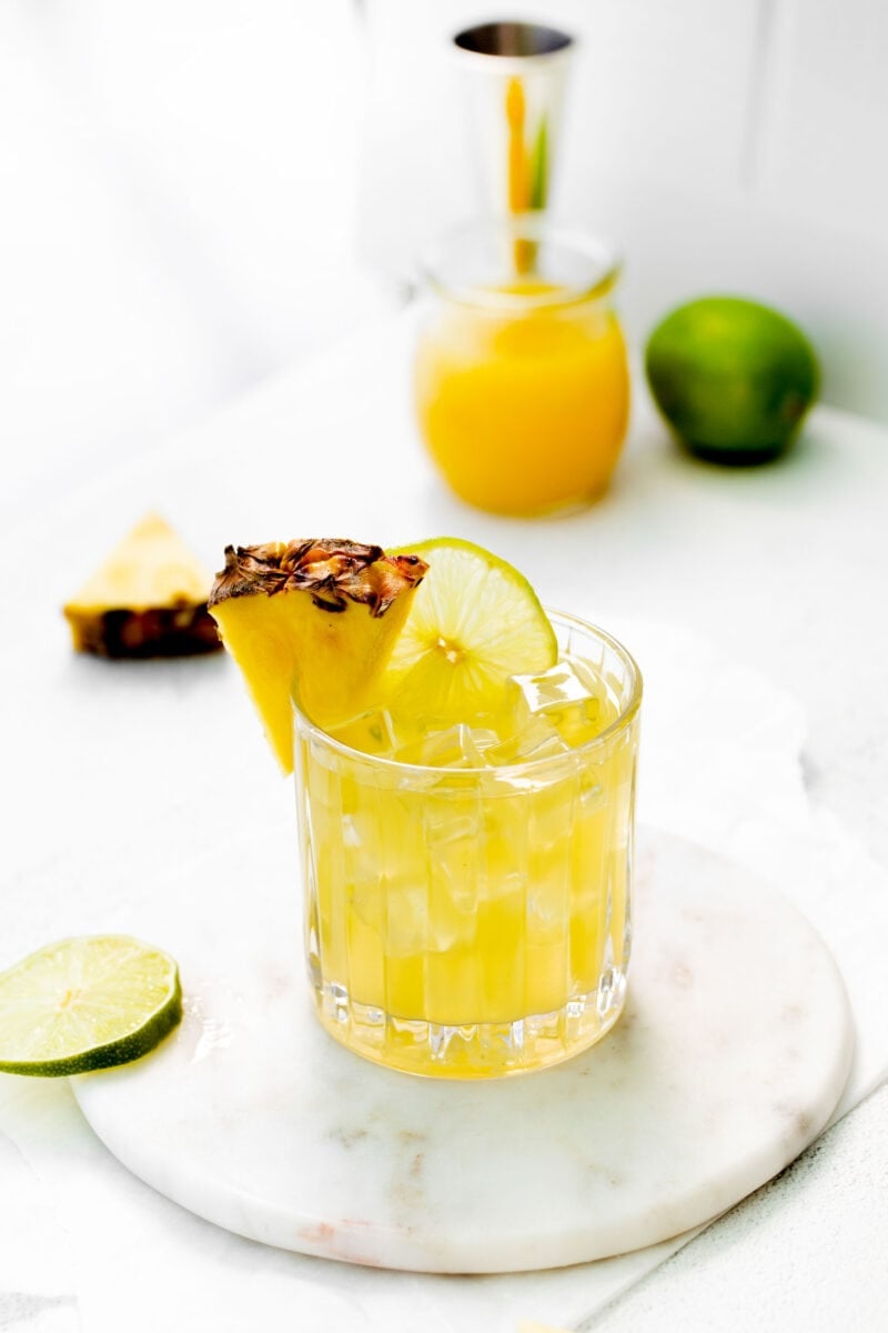 a glass of pineapple paloma is garnished with a pineapple wedge