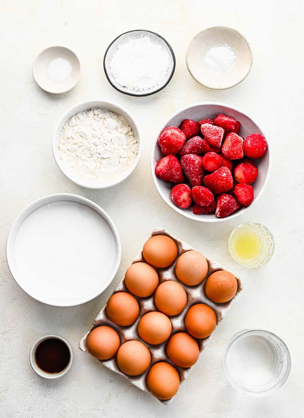 Ingredients for strawberry angel food cake separated into bowls.