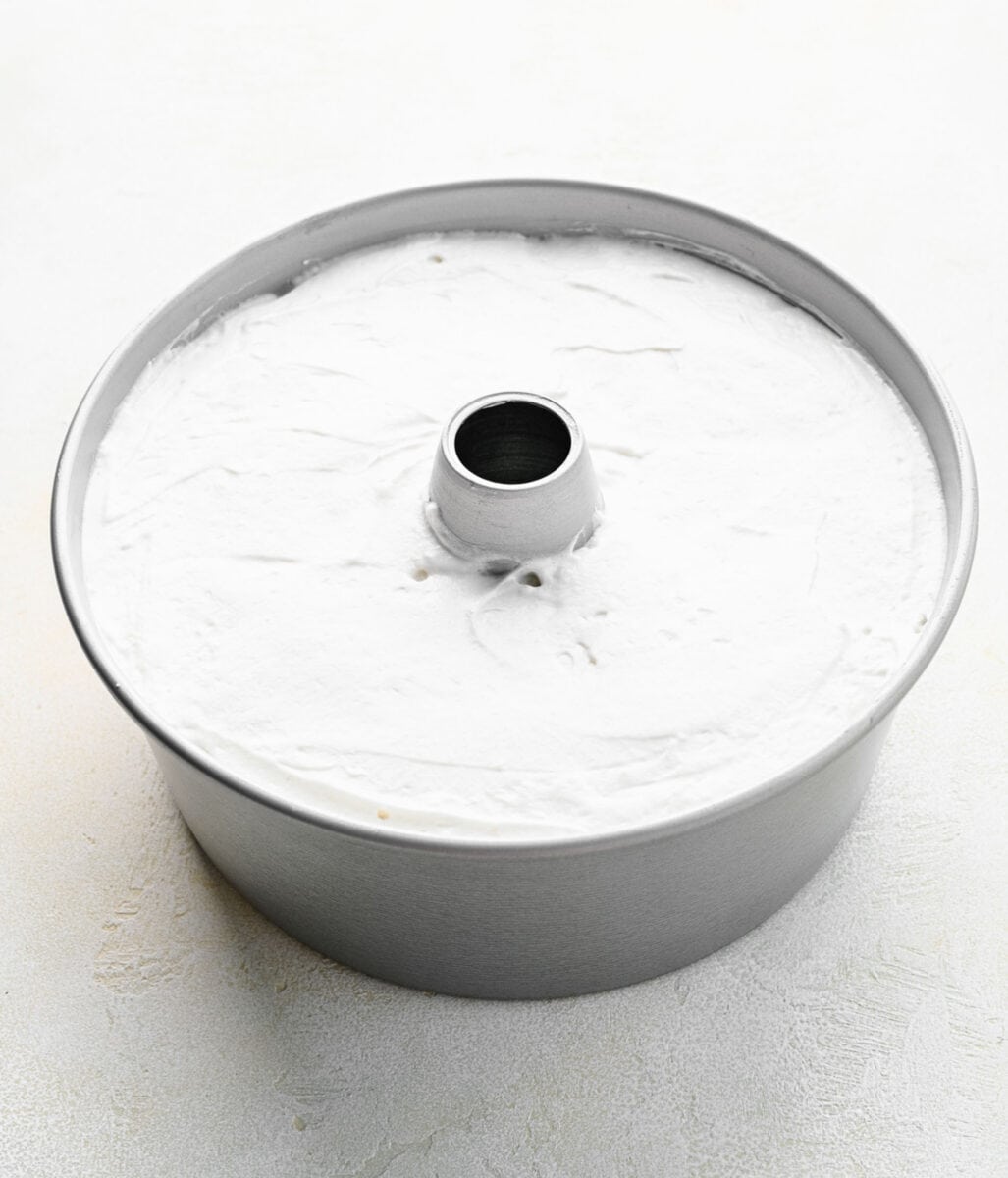 Angel food cake batter smoothed into an angel food cake pan.