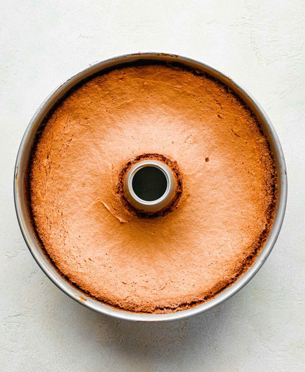 Angel food cake cooling in an angel food cake pan.