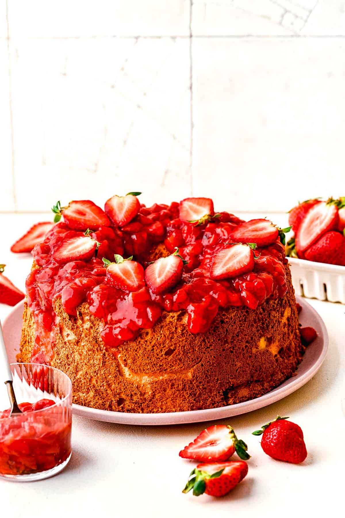 Strawberry angel food cake topped with fresh strawberries.