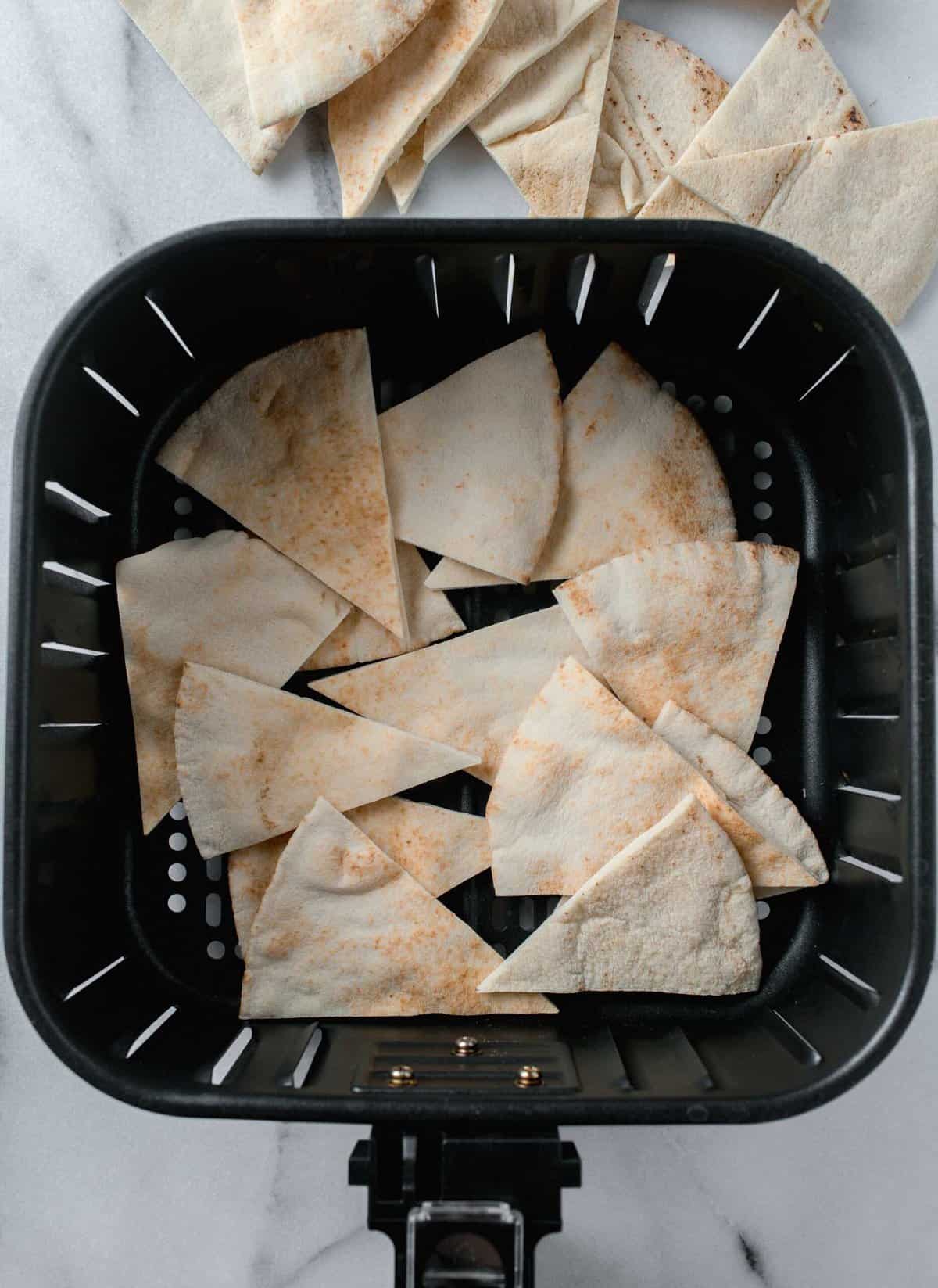 pita bread triangle slices in a basket of an air fryer
