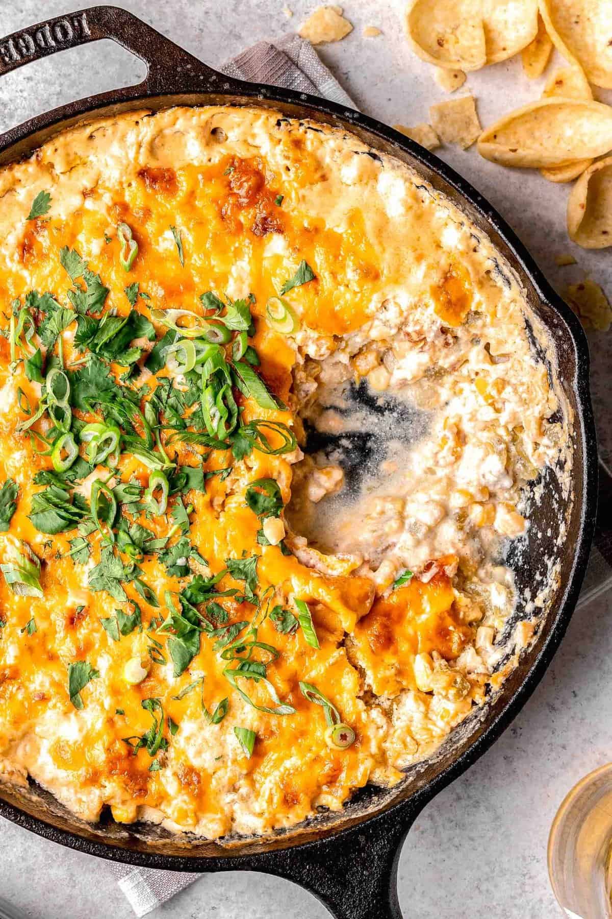 inside of corn dip in a cast iron skillet next to tortilla chips
