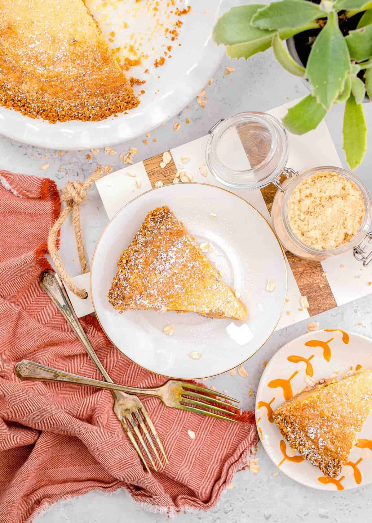 pie has been sliced and plated on two different plates next to the dish