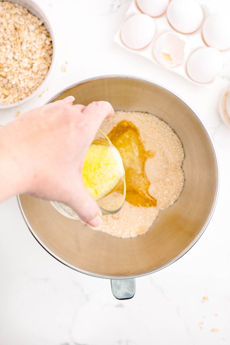 melted butter is being poured into a mixing bowl