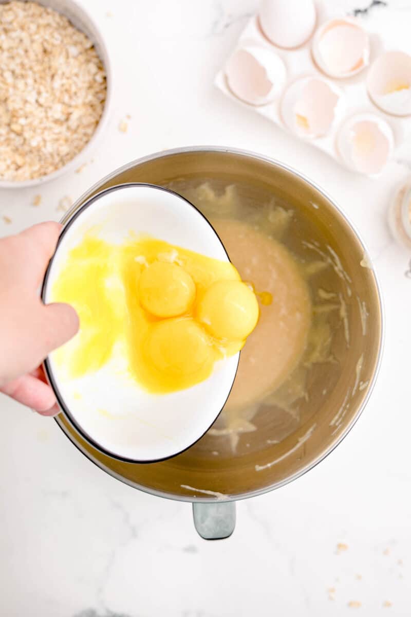 egg yolks are being added to a mixing bowl
