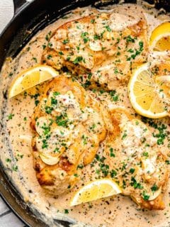 lemons are placed in a skillet with cooking garlic butter chicken