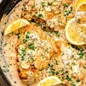 lemons are placed in a skillet with cooking garlic butter chicken