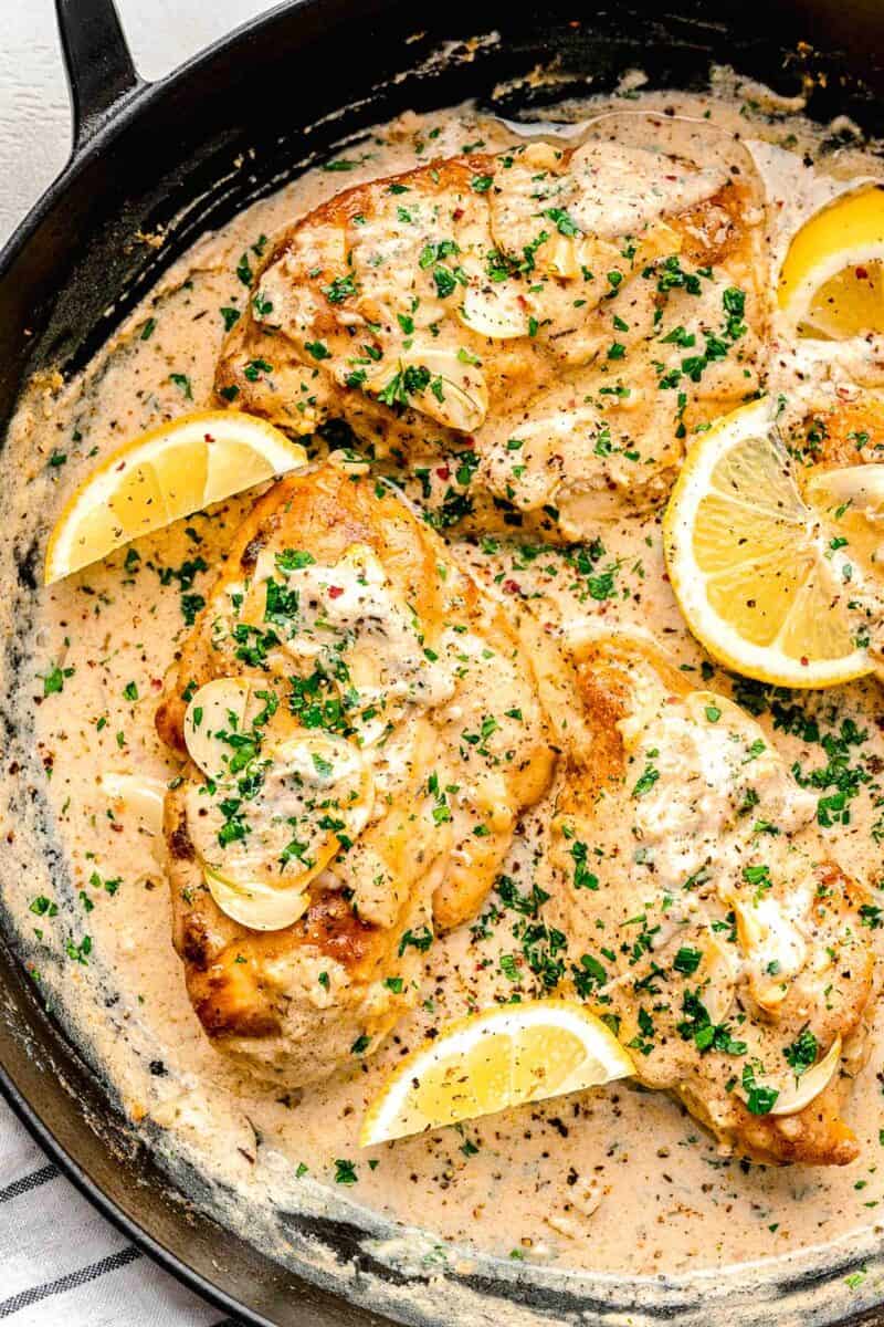 lemons are placed in a skillet with cooking garlic butter chicken