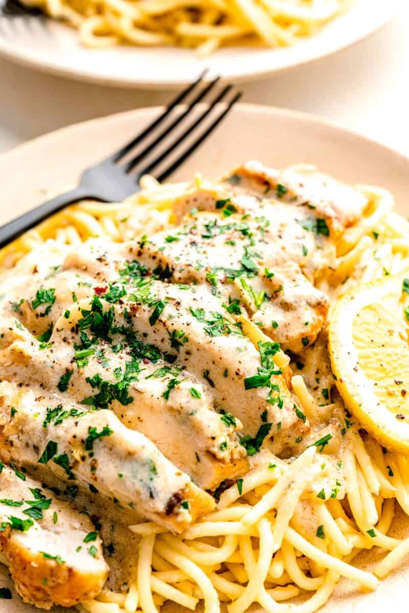 sliced garlic butter chicken is served over noodles