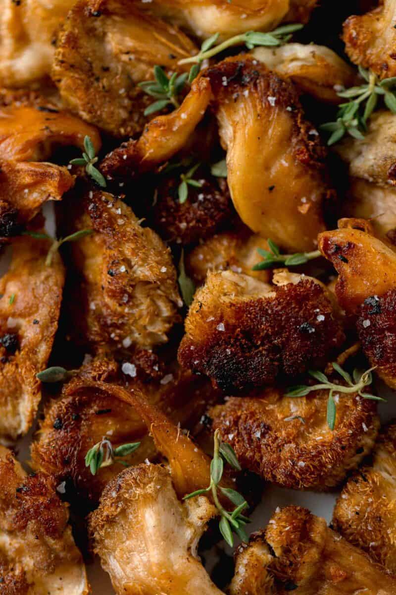 up close image of lion's mane mushrooms with fresh thyme and seat salt sprinkled on top