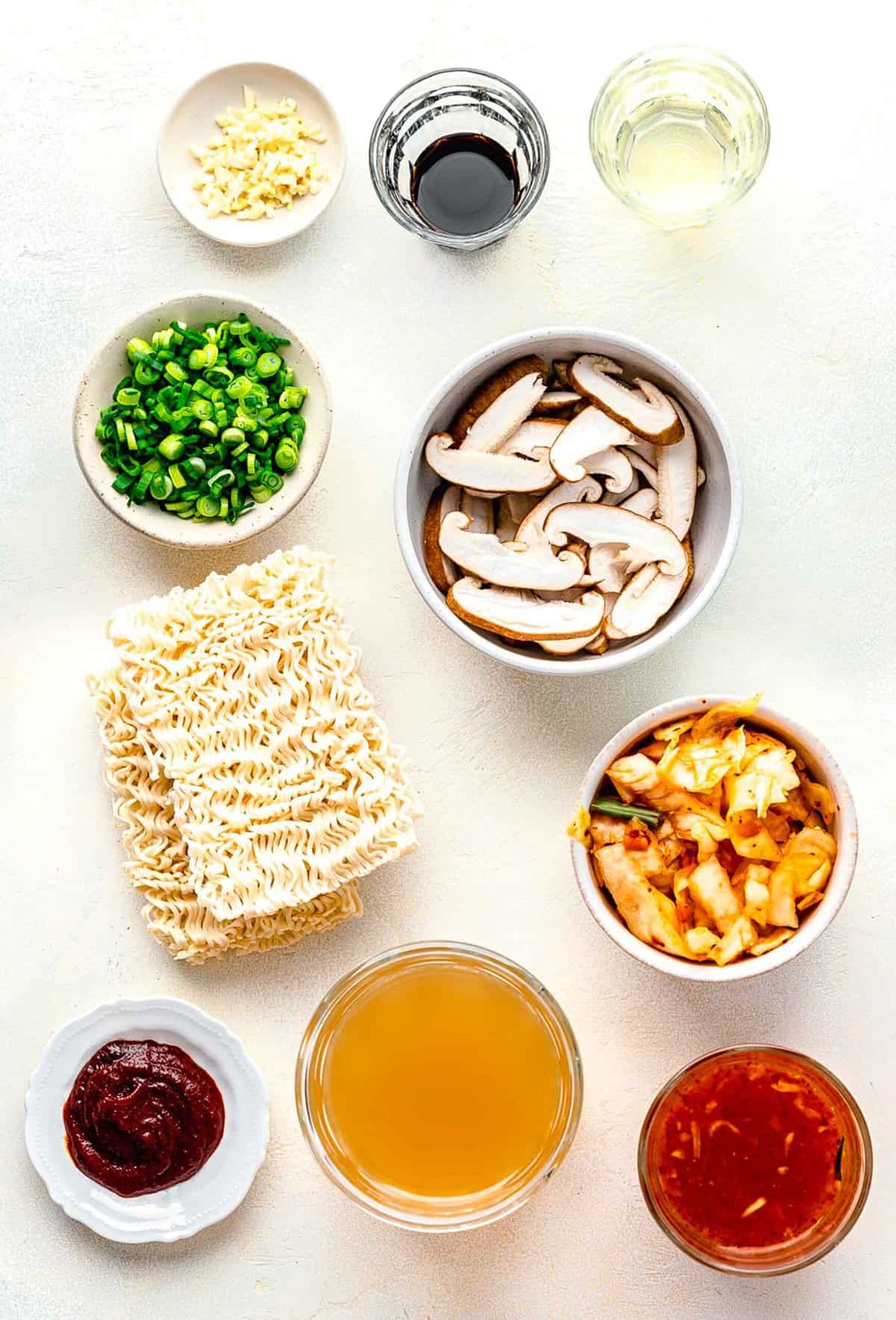 Ingredients for kimchi ramen separated into bowls.