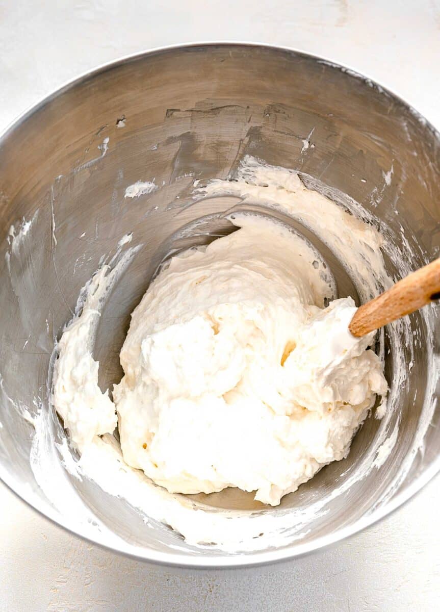 Folding whipped cream into no bake pie filling.
