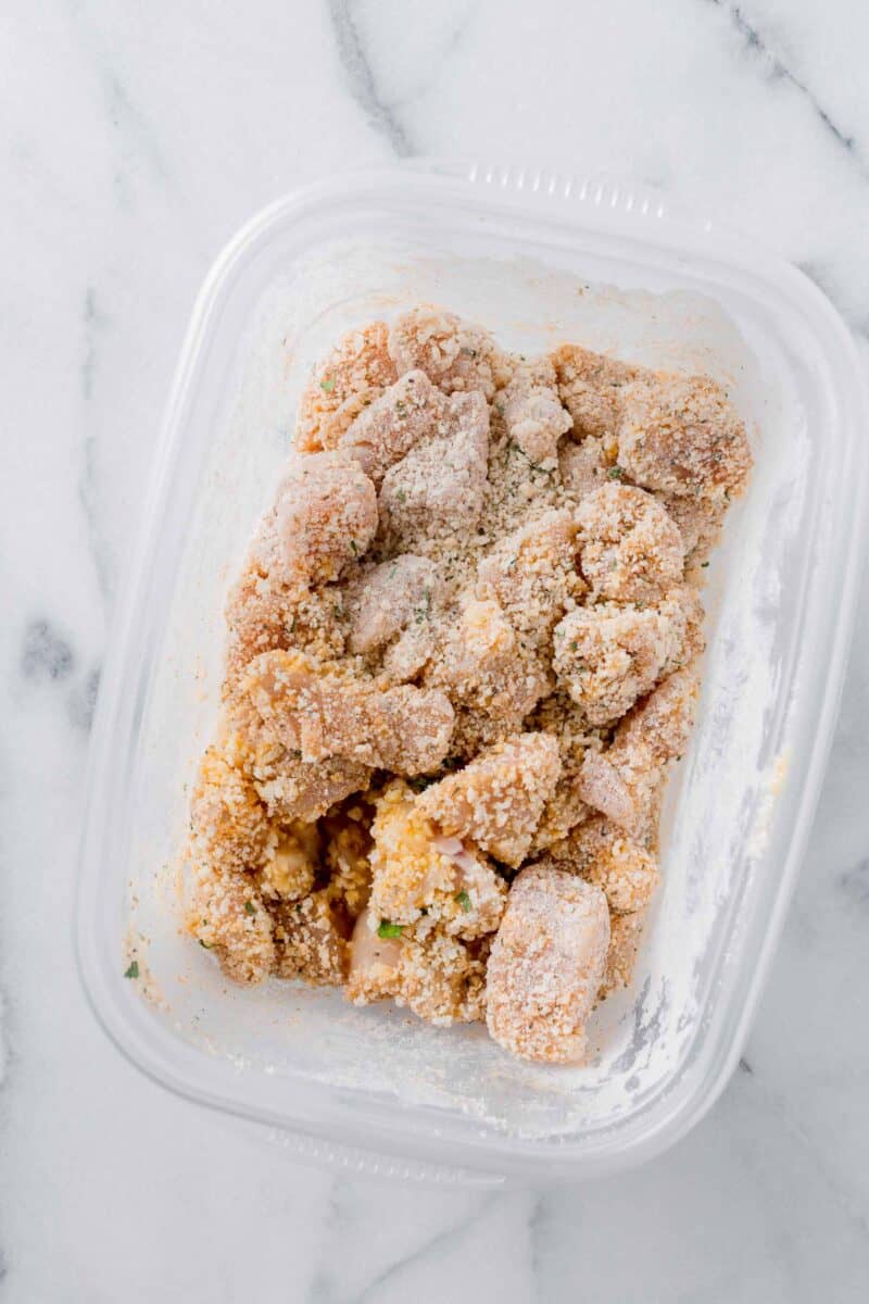 chicken covered in breadcrumb mixture in a plastic container