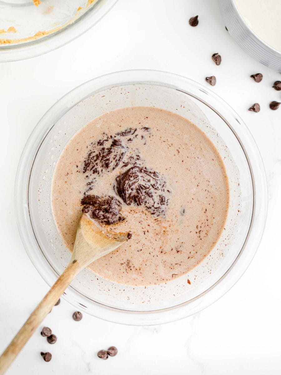 brownie batter is being mixed in a glass bowl