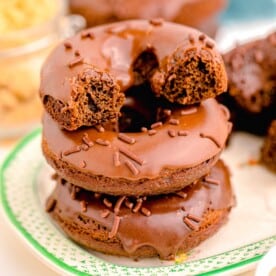 a halved donut is stacked on top of two other donuts