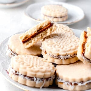 several cookies are placed on a white plate with a halved cookie on top