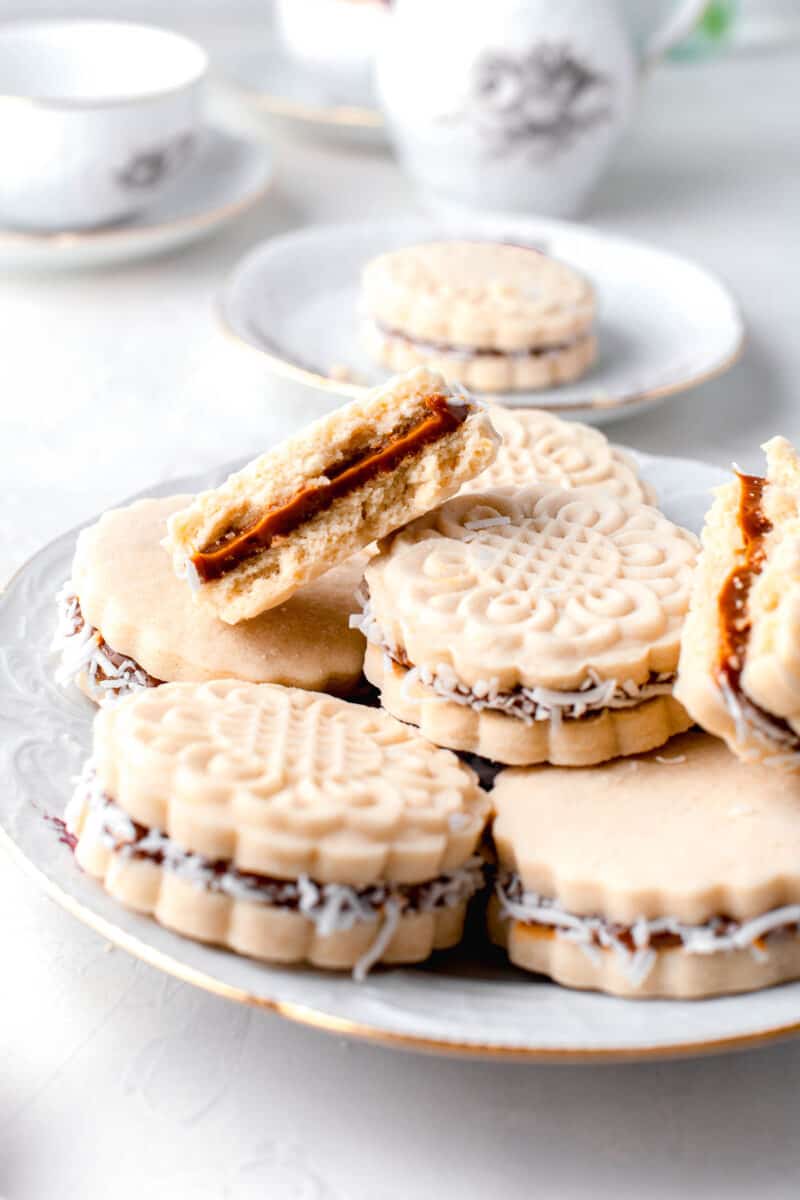 several cookies are placed on a white plate with a halved cookie on top